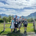 Familie Nagele in Tracht vor Bergpanorama.