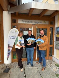 Eggstätts Bürgermeister Christoph Kraus (Mitte), Zweiter Bürgermeister Stefan Meier (rechts) und TI-Leitung Julia Kraus (links) freuen sich über das neue Druckwerk.