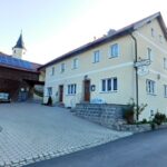 Gaststätte Scherm mit der St.-Ursula-Kirche im Hintergrund.