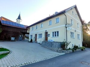 Gaststätte Scherm mit der St.-Ursula-Kirche im Hintergrund.