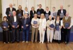 Arbeitsministerin Ulrike Scharf mit den 15 geehrten Arbeitsjubilarinnen und -jubilaren