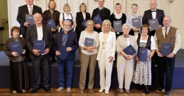 Arbeitsministerin Ulrike Scharf mit den 15 geehrten Arbeitsjubilarinnen und -jubilaren