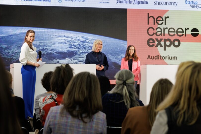 Bayerns Frauenministerin Ulrike Scharf, Moderatorin Andrea Lauterbach (l.) und Dr. Suzanna Randall auf der Bühne.