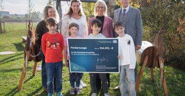 Familienministerin Ulrike Scharf bei der Übergabe des Förderschecks an Bürgermeister Thomas Bartl sowie Susann Mair und Alexandra Geigerseder vom Kinderhort St. Martin.