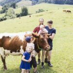 Theresa und Sepp Steinmüller mit Kindern und Rindern auf der Weide.