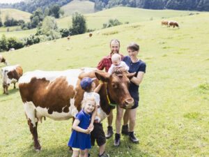 Theresa und Sepp Steinmüller mit Kindern und Rindern auf der Weide.