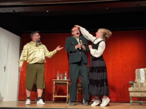 Der eigentlich rothaarige Titus (Michael Binsteiner) wird von seiner Auserwählten (Ronja Langer) und deren Liebhaber (Stefan Fleidl) ordentlich in die Mangel genommen.