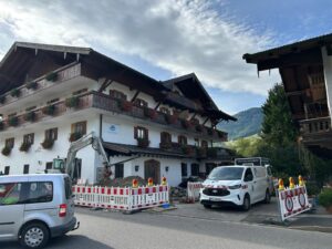 Baustelle mit Bagger und Absperrungen an einer Straße