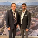 Landesrat René Zumtobel und Oberbürgermeister Abuzar Erdogan vor einem Stadtpanorama.