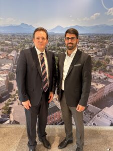 Landesrat René Zumtobel und Oberbürgermeister Abuzar Erdogan vor einem Stadtpanorama.