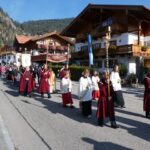 Gemeindemitglieder und Ministranten folgen dem Zug.