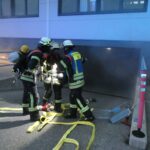 Atemschutztrupps beraten sich am Eingang zur Tiefgarage.