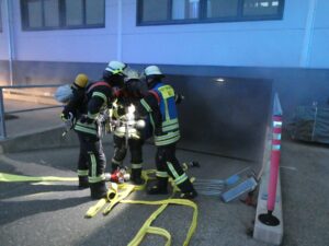 Atemschutztrupps beraten sich am Eingang zur Tiefgarage.