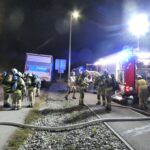Mehrere Einsatzkräfte an Löschfahrzeugen und einem Halton-Lkw während der Übung.