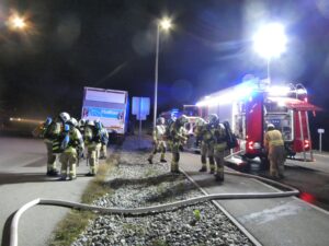 Mehrere Einsatzkräfte an Löschfahrzeugen und einem Halton-Lkw während der Übung.