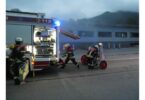 Aufbau am Löschfahrzeug mit Einsatzkräften vor der Halle.