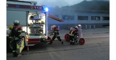 Aufbau am Löschfahrzeug mit Einsatzkräften vor der Halle.