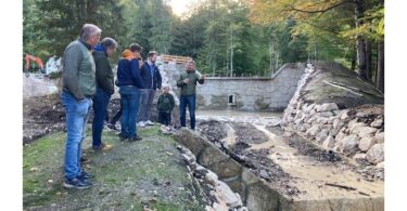 Franz Rasp vom Wasserwirtschaftsamt Traunstein erläutert die abgeschlossenen Hochwasserschutzmaßnahmen am Schlierbach.
