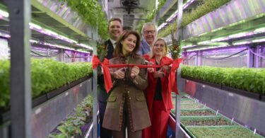 Eröffnung der LWG-Indoor-Farm: Personen schneiden ein rotes Band im Inneren einer vertikalen Indoor-Farm durch