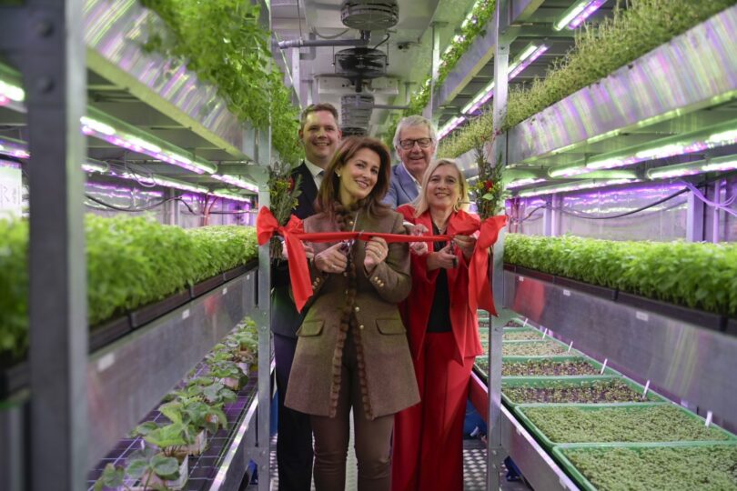 Eröffnung der LWG-Indoor-Farm: Personen schneiden ein rotes Band im Inneren einer vertikalen Indoor-Farm durch