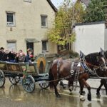 Wagen mit Angehörigen des Trachtenvereins Alt Rosenheim und zwei Pferden beim Leonhardiritt.