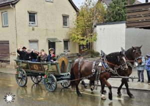 Wagen mit Angehörigen des Trachtenvereins Alt Rosenheim und zwei Pferden beim Leonhardiritt.