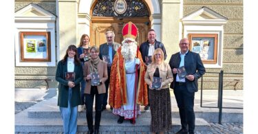 Team der Stadt Altötting und des Altöttinger Wirtschaftsverbands präsentiert die Adventsbroschüre gemeinsam mit dem Nikolaus.