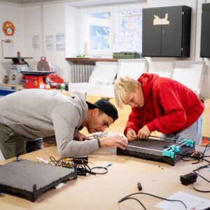 Manuel Hohenester, Leiter der Werkstatt am Schülerforschungszentrum, mit einem Teilnehmenden beim Bau einer Zeichenmaschine.